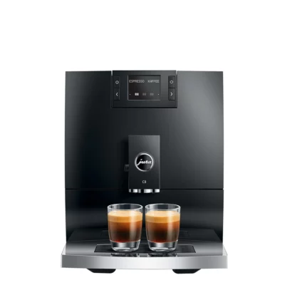 Une machine à café automatique JURA C8 Piano Black (SA) élégante et moderne avec un affichage numérique affichant « ESPRESSO » et « KOFFEE ». Sous l'écran, deux verres transparents sont remplis d'espresso, présentant une crème riche en couches sur un bac d'égouttement chromé. La machine a une finition noire.