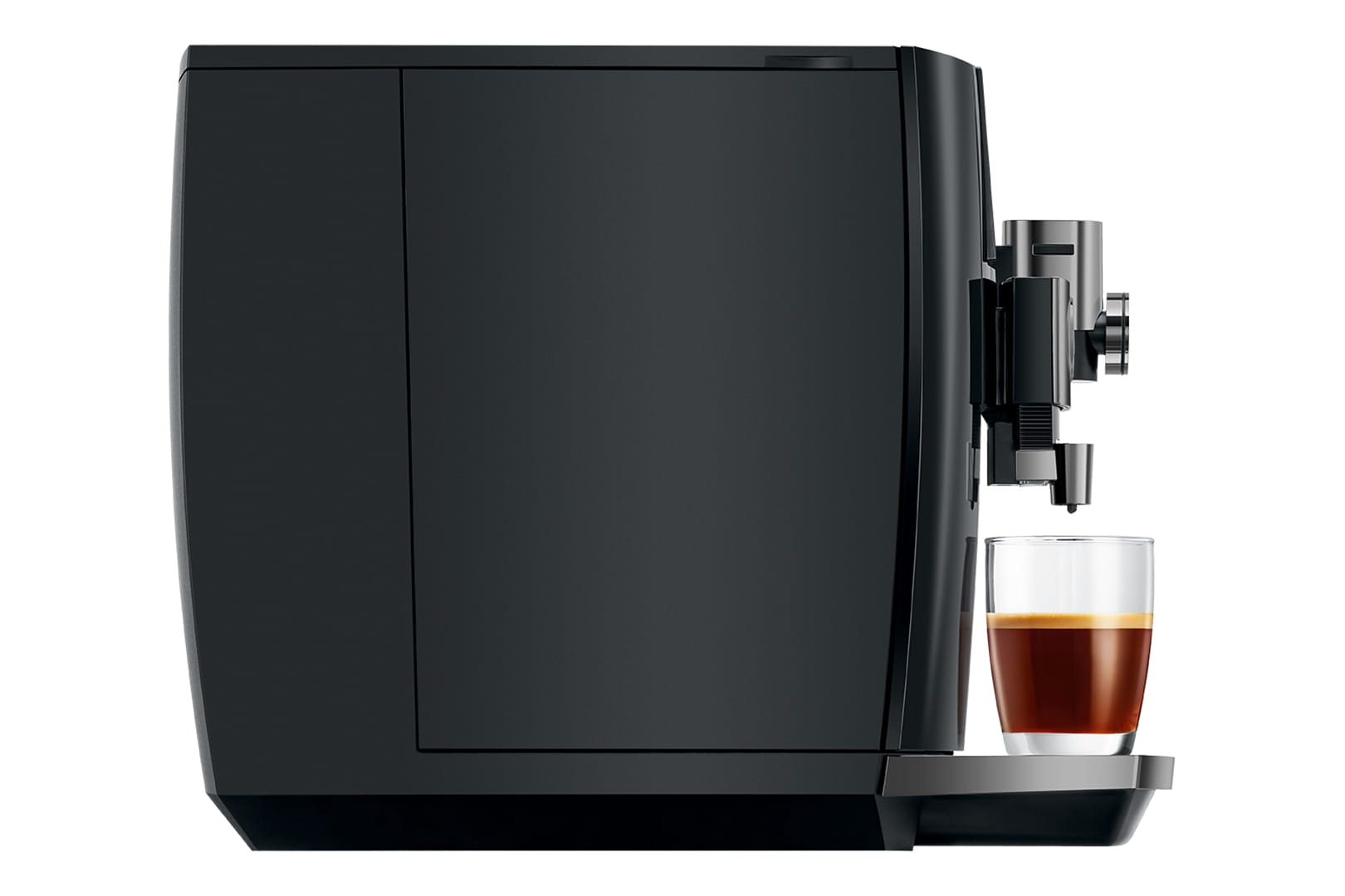 Une élégante machine à expresso noire prépare du café dans une tasse en verre transparent placée sur son bac d'égouttage. La machine présente des lignes épurées et un design moderne, la tasse présentant une couche de crème sur le dessus de l'espresso.